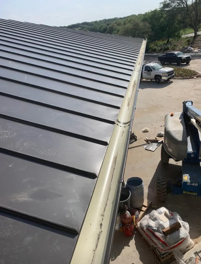 Standing seam panel and gutter detail on a metal roofing jobsite in Lowell